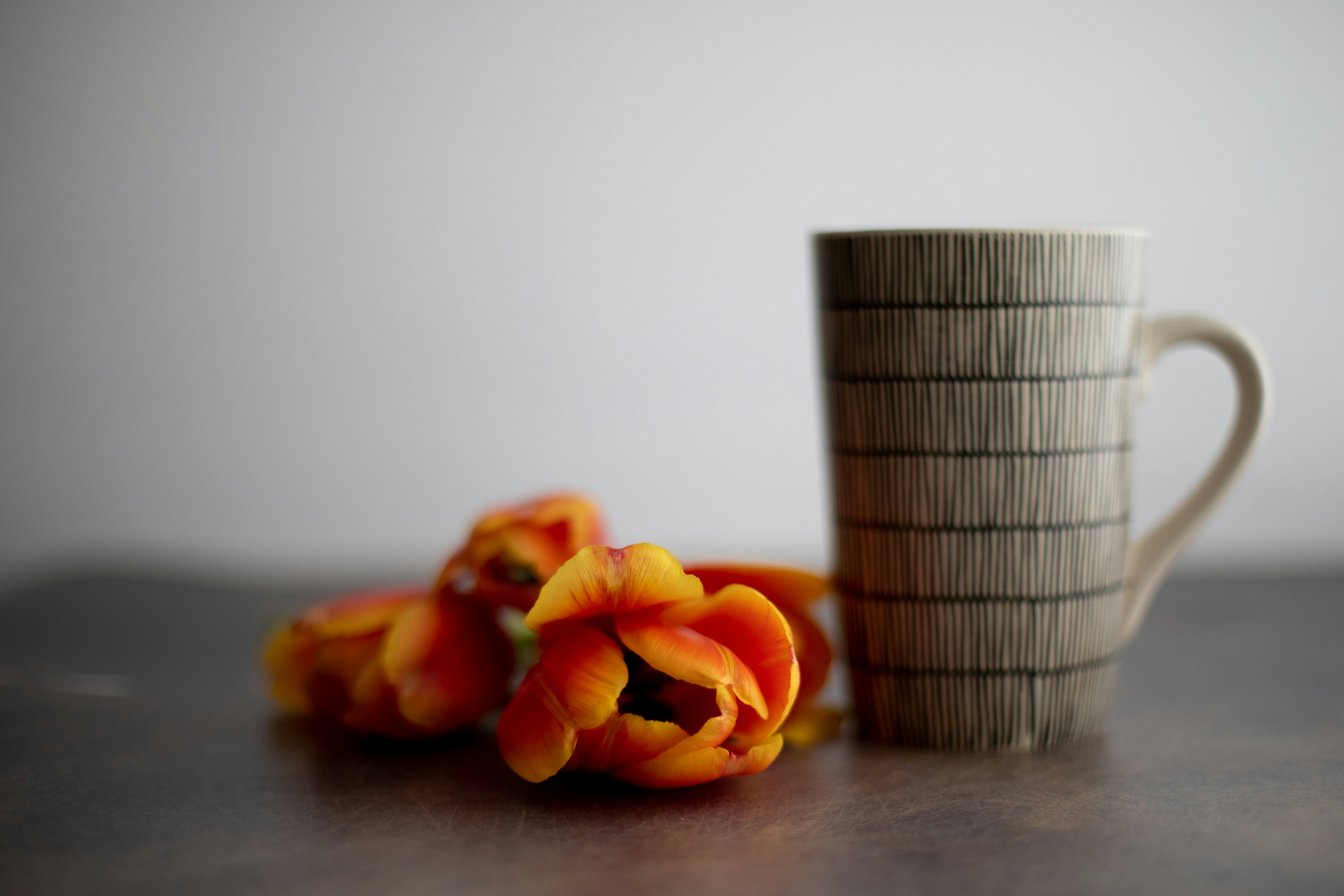 orange tulips in gray ceramic mug